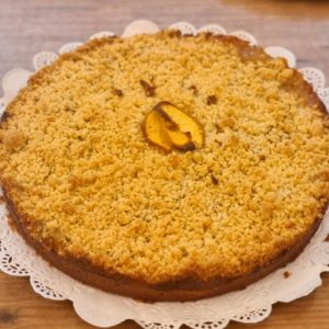 Streusel de durazno, kuchen relleno con duraznos sobre crema pastelera y cubierto con migas crocantes