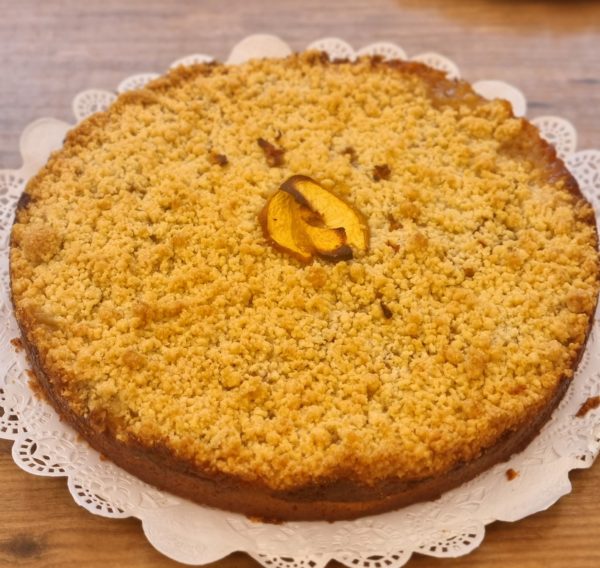 Streusel de durazno, kuchen relleno con duraznos sobre crema pastelera y cubierto con migas crocantes